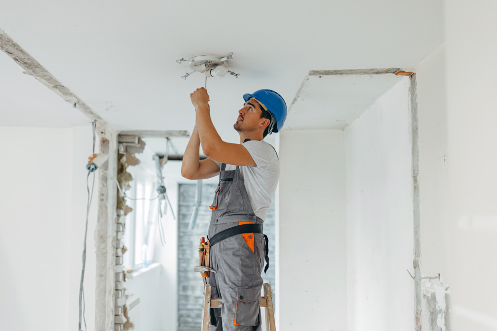 A man painting a ceilinf